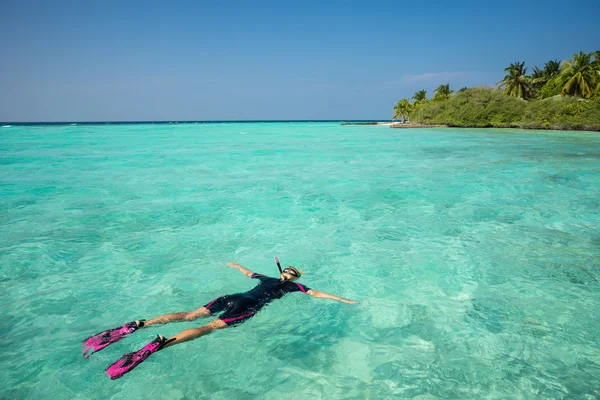 Mujer haciendo snorkel en aguas tropicales claras frente a isl exótico —  Fotos de Stock