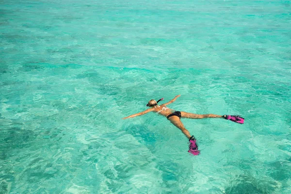 Femme plongée avec tuba dans les eaux tropicales claires en face de l'île exotique — Photo