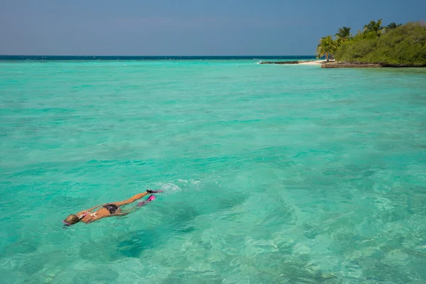 Mujer haciendo snorkel en aguas tropicales claras frente a isl exótico —  Fotos de Stock