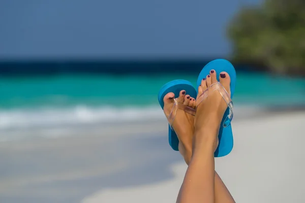 Primer plano del pie femenino en el agua azul en la playa tropical . — Foto de Stock