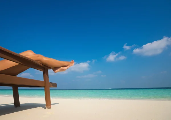 Jonge vrouw om te zonnebaden op een ligstoel. Benen. — Stockfoto