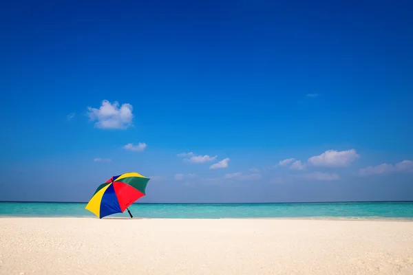 Parasoll på en solig dag, havet i bakgrunden — Stockfoto