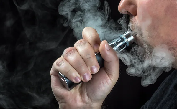 Close-up de um homem vaporizando um cigarro eletrônico — Fotografia de Stock