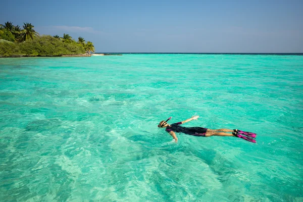 Frau schnorchelt in klaren tropischen Gewässern vor exotischer Insel — Stockfoto