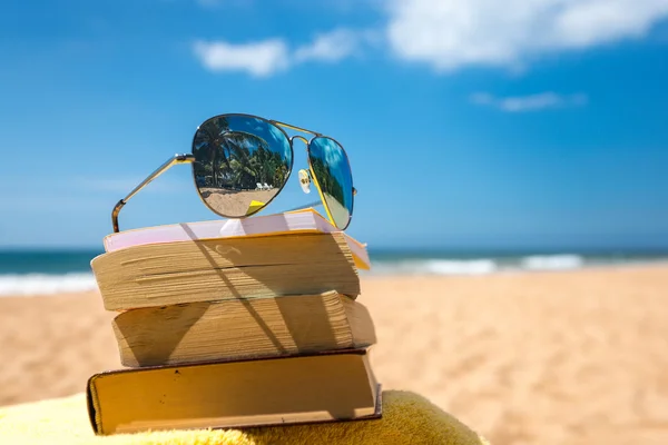 Knihy a sluneční brýle na pláži — Stock fotografie