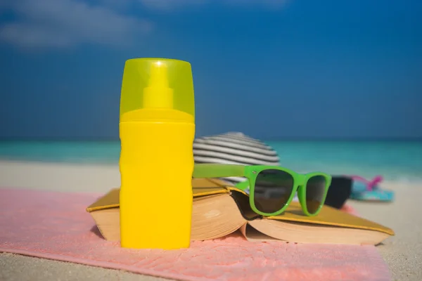 Sonnencreme, Hut und Sonnenbrille am tropischen Strand — Stockfoto