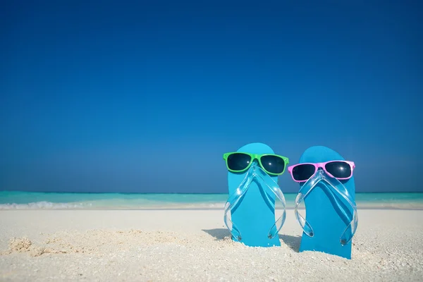 Slippers en zonnebrillen aan zee — Stockfoto