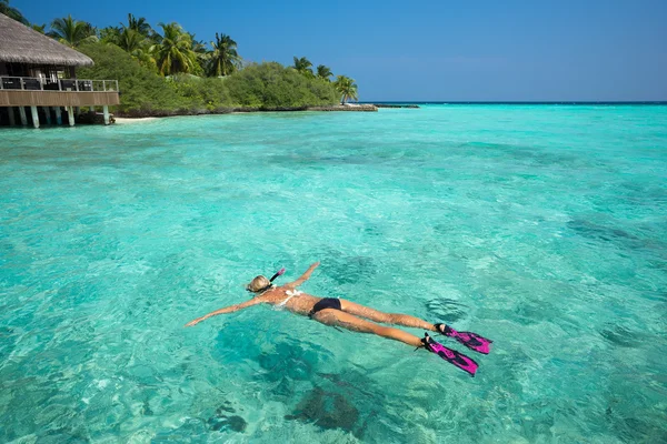 Женщина ныряет с маской в прозрачных тропических водах перед экзотическим островом — стоковое фото