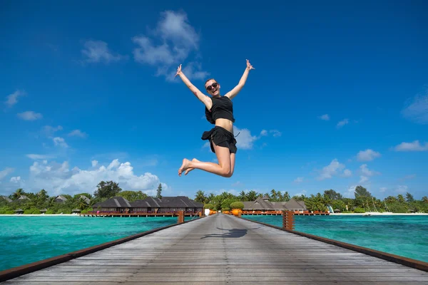 Joyeux jeune femme sautant sur la plage — Photo