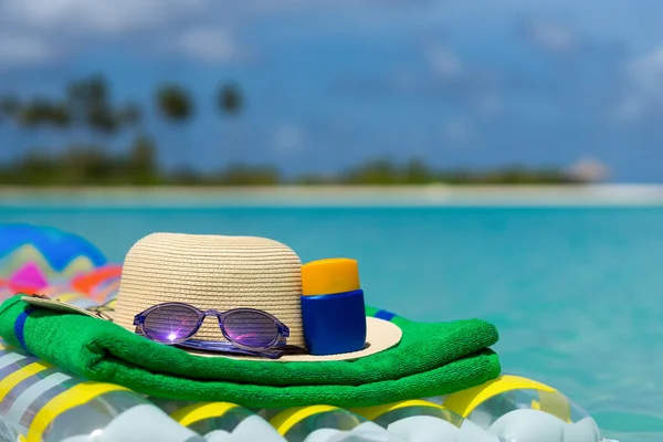 Sonnenbrille und Strohhut auf einer Luftmatratze im Meer. Tropischer Sommer — Stockfoto