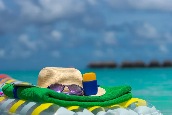 Sonnenbrille und Strohhut auf einer Luftmatratze im Meer. Tropischer Sommer — Stockfoto