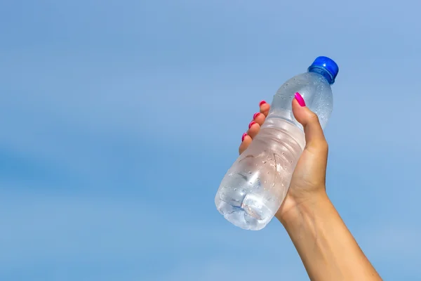 Mujer mano celebración botella de agua al aire libre — Foto de Stock