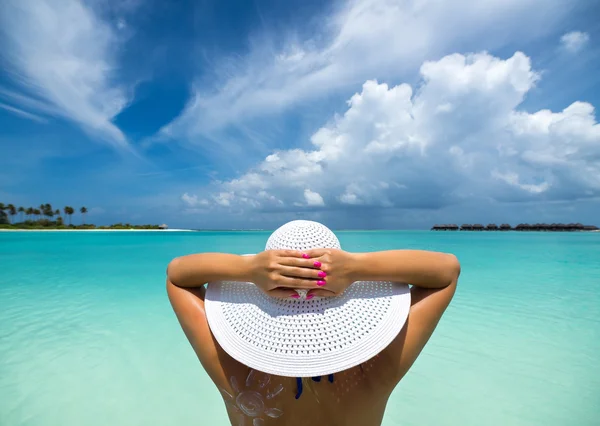 Vrouw met hoed op het strand — Stockfoto