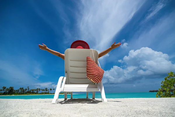 Mujer joven tomando el sol en una tumbona en la playa tropical —  Fotos de Stock