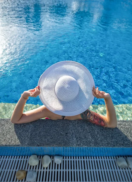 Hermosa mujer tomando el sol junto a la piscina vista superior horizontal. Suma —  Fotos de Stock