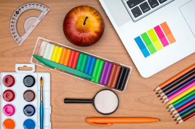 okul malzemeleri ve yukarıdan gelen ahşap okul masasında tablet