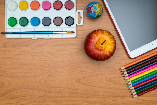 School supplies and tablet on wooden school desk from above — Stock Photo, Image