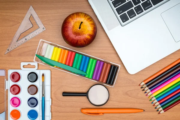 School supplies and tablet on wooden school desk from above — Stock Photo, Image