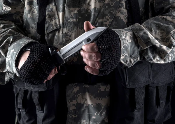 Military man with a knife in a hand close up on the black background — Stock Photo, Image