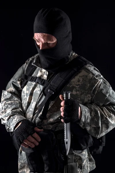 Военный с ножом в руке закрывается на черном фоне — стоковое фото