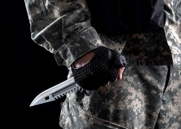 Military man with a knife in a hand close up on the black background — Stock Photo, Image