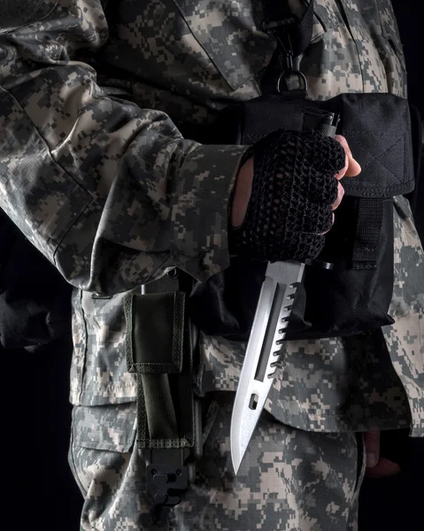 Militar homem com uma faca em uma mão perto do fundo preto — Fotografia de Stock