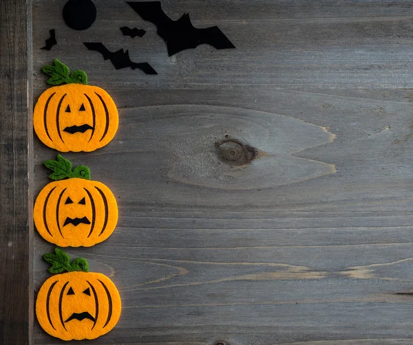 Whimsical Halloween background image of handmade felt jack-o-lantern on rustic wood — Stock Photo, Image