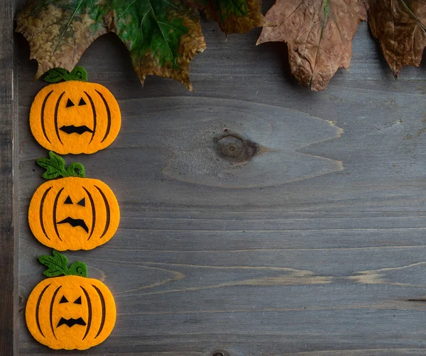 Whimsical Halloween background image of handmade felt jack-o-lantern on rustic wood — Stock Photo, Image