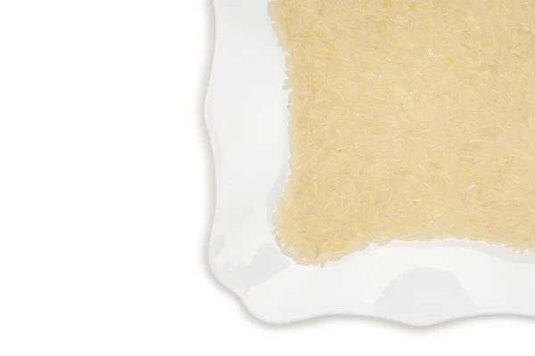 White long rice on the white background, uncooked raw cereals, macro on the plate — Stock Photo, Image