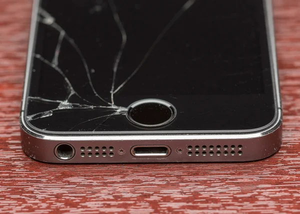 MOSCÚ, RUSIA - 6 de octubre de 2014: Foto de un iPhone 5. iPhone 5 roto es un teléfono inteligente desarrollado por Apple Inc. Es parte de la línea iPhone. iPhone es el teléfono inteligente favorito del mundo . — Foto de Stock