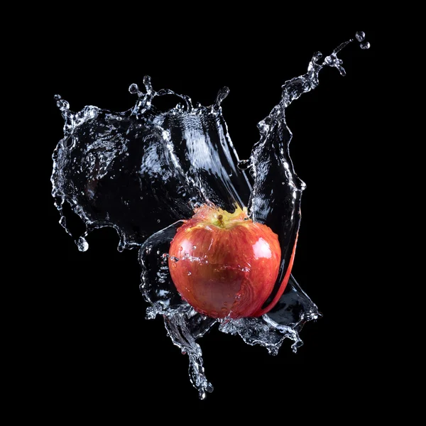 Červené jablko, stříkající do vody — Stock fotografie