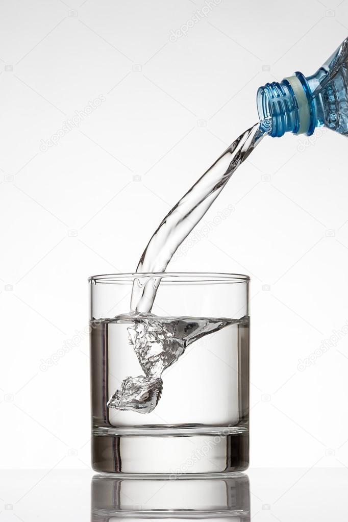 Cold water bottle pour water to glass on white background