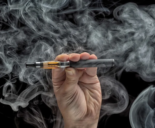 Mano sosteniendo un cigarrillo electrónico sobre un fondo oscuro — Foto de Stock