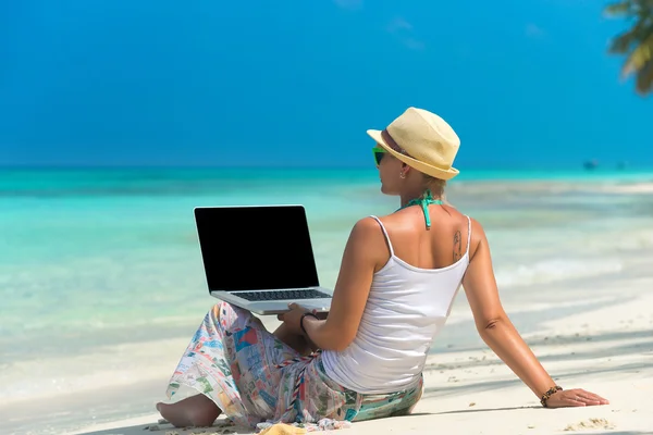 Женщина на экзотическом тропическом пляже с ноутбуком — стоковое фото
