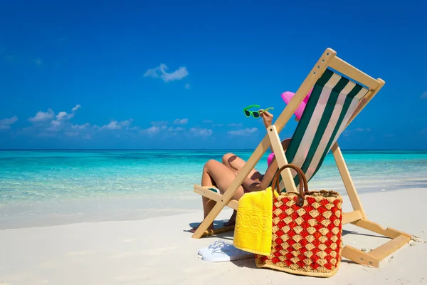 Jong meisje liggen op een ligstoel strand met glazen in de hand op de — Stockfoto