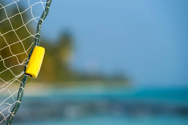 Red de pesca sobre un fondo de playa tropical — Foto de Stock