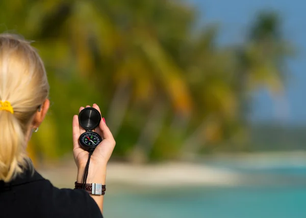 Brújula en mano de mujer contra paisaje de playa . —  Fotos de Stock