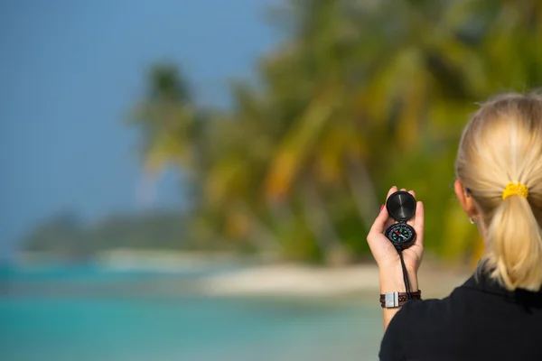 Kompass på kvinna hand mot stranden landskap. — Stockfoto