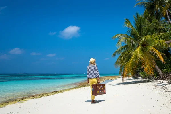 Hermosa chica con una maleta vintage en una playa — Foto de Stock
