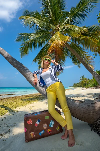 Hermosa chica con una maleta vintage en una playa —  Fotos de Stock