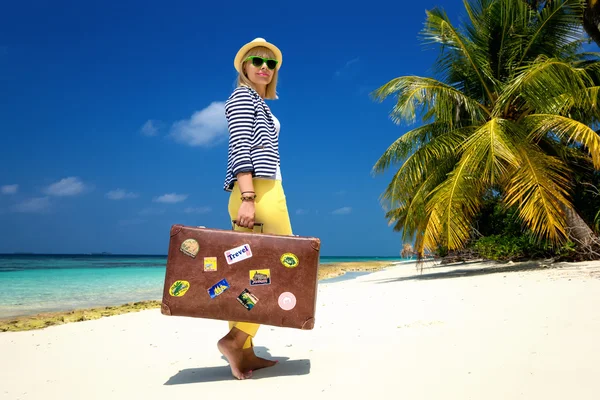 Hermosa chica con una maleta vintage en una playa —  Fotos de Stock