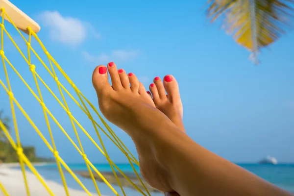 Vrouw voeten in hangmat op het strand — Stockfoto