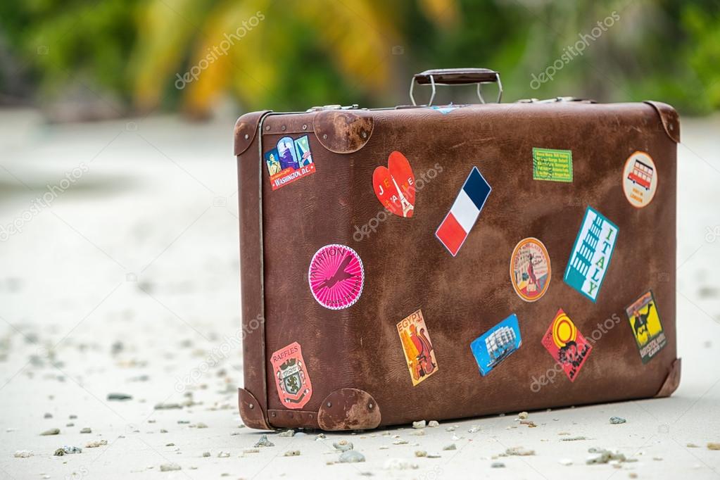 Travel vintage suitcase is alone on a beach