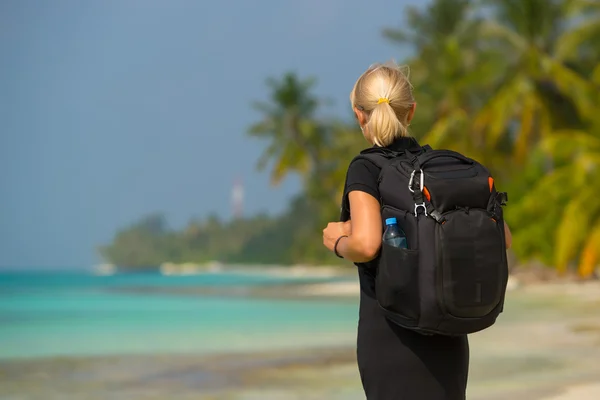 Joven turista con mochila caminando en playa tropical —  Fotos de Stock