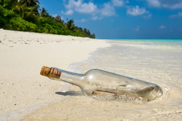 Mensagem em garrafa lavada em terra em praia tropical . — Fotografia de Stock