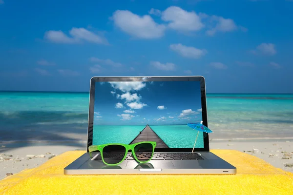 Počítač notebook na pláži - obchodní cesty pozadí — Stock fotografie