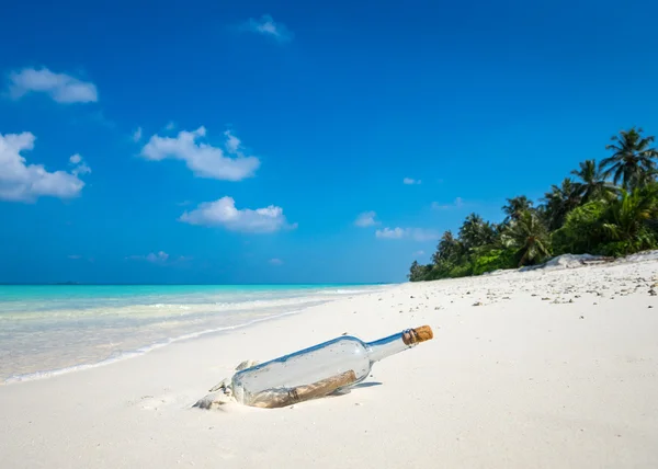 Message in a bottle washed ashore on a tropical beach. — Stock Photo, Image