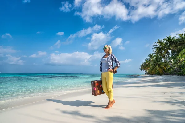 Schöne Mädchen mit einem Vintage-Koffer in einem Strand — Stockfoto