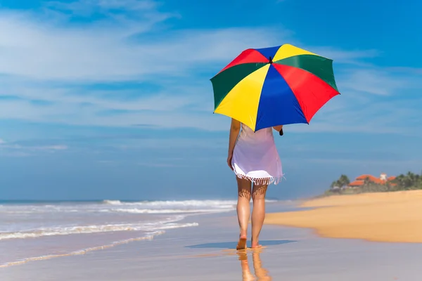 Meisje met een kleurrijke paraplu op het zandstrand — Stockfoto
