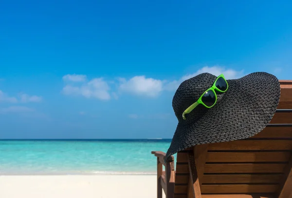 Solstolar med hatt på vit sandstrand — Stockfoto